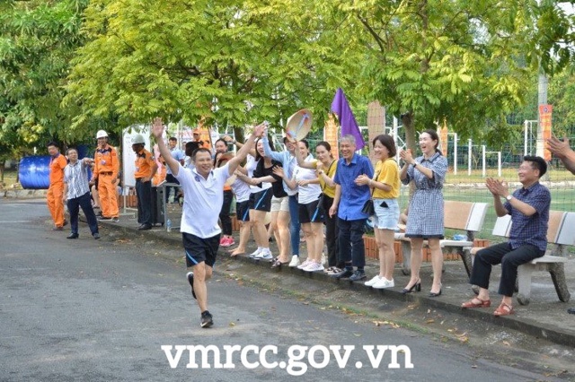 A group of people running on a road with trees and people watchingDescription automatically generated with low confidence